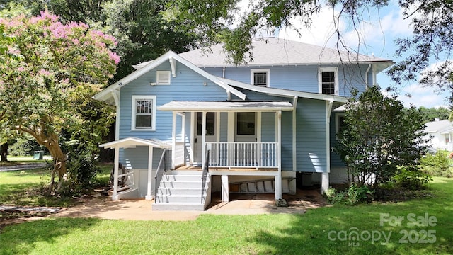 back of house featuring a lawn and a porch