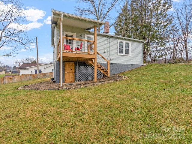 back of property with a lawn and a deck