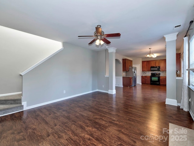 unfurnished living room featuring dark hardwood / wood-style flooring and ceiling fan with notable chandelier