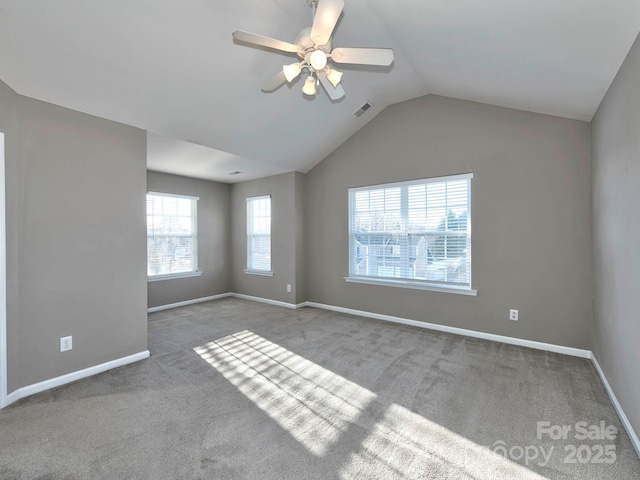 carpeted spare room featuring vaulted ceiling and ceiling fan