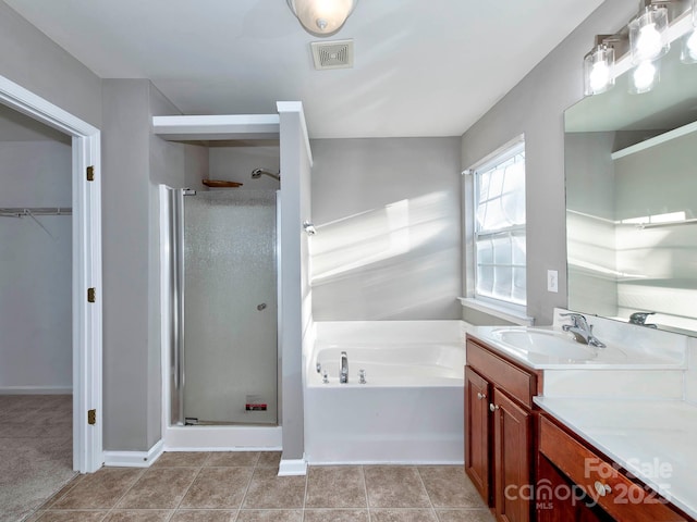 bathroom with tile patterned flooring, vanity, and plus walk in shower