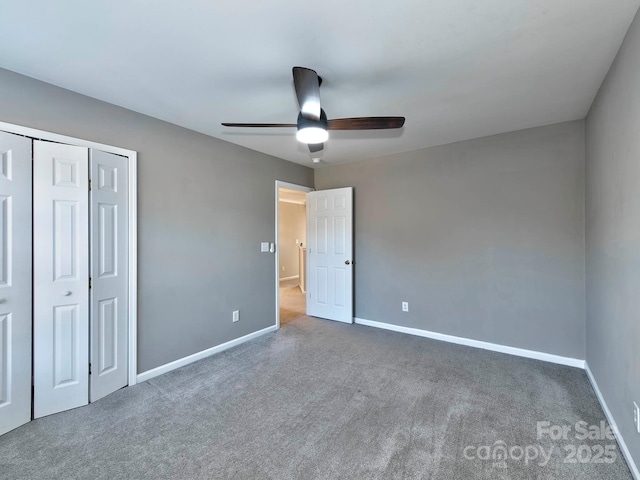 unfurnished bedroom with a closet, dark carpet, and ceiling fan