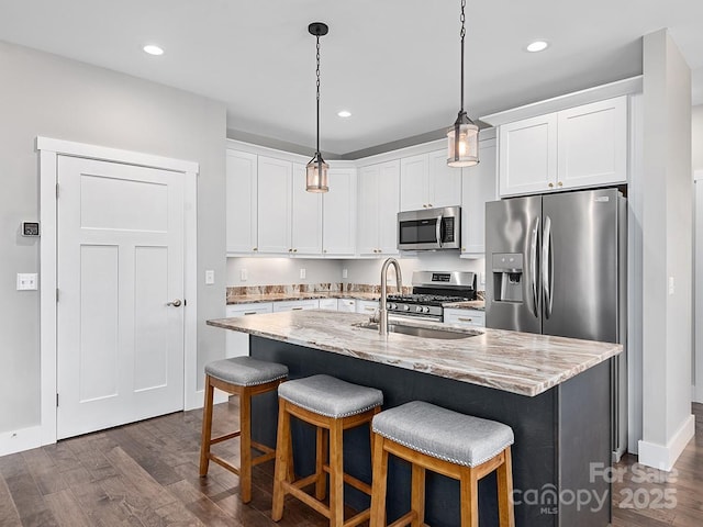 kitchen with a center island with sink, sink, white cabinetry, and stainless steel appliances