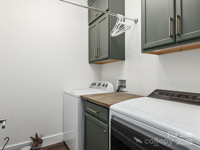 laundry area with washer and dryer, cabinets, and dark wood-type flooring