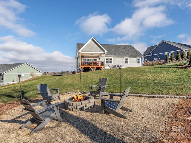 back of house featuring a yard, a fire pit, and a deck