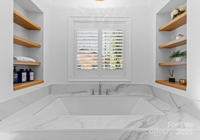 bathroom with built in shelves and a garden tub