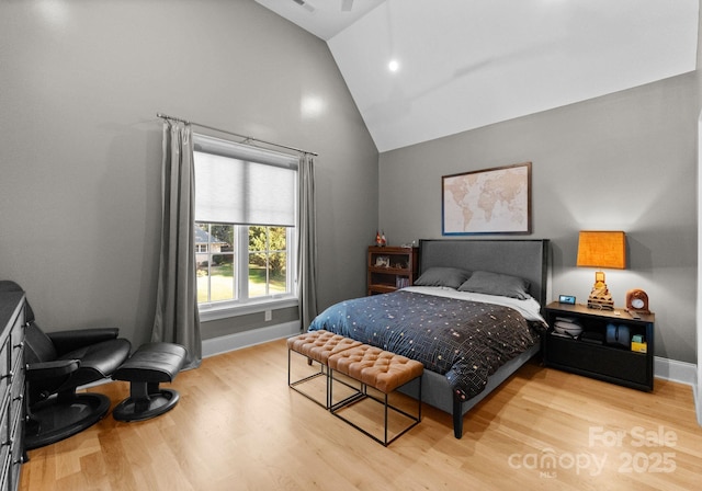 bedroom with light hardwood / wood-style floors and lofted ceiling