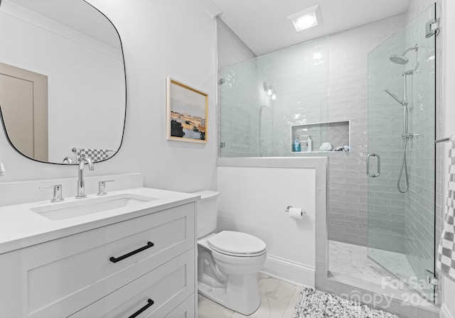 bathroom with a shower stall, baseboards, toilet, marble finish floor, and vanity