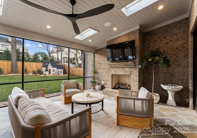 sunroom / solarium with an outdoor brick fireplace, ceiling fan, lofted ceiling with skylight, and wood ceiling