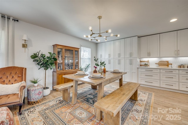 dining room featuring light hardwood / wood-style floors and a notable chandelier