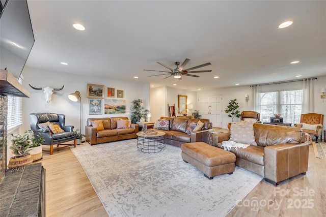 living room with ceiling fan and light hardwood / wood-style floors