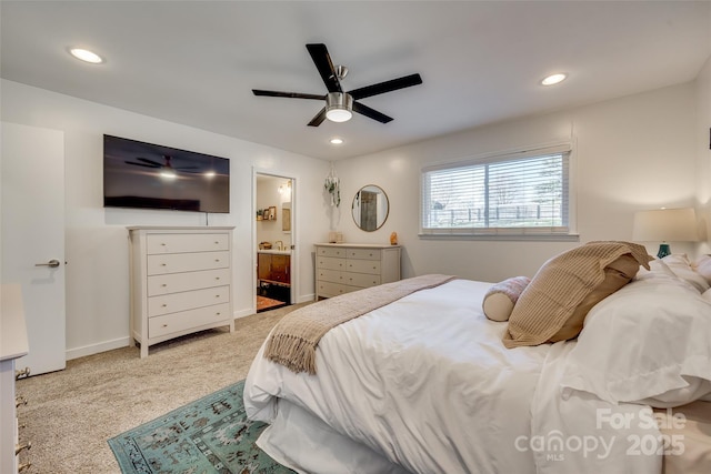 bedroom featuring connected bathroom, light colored carpet, and ceiling fan