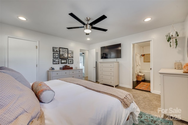 carpeted bedroom with ensuite bath and ceiling fan