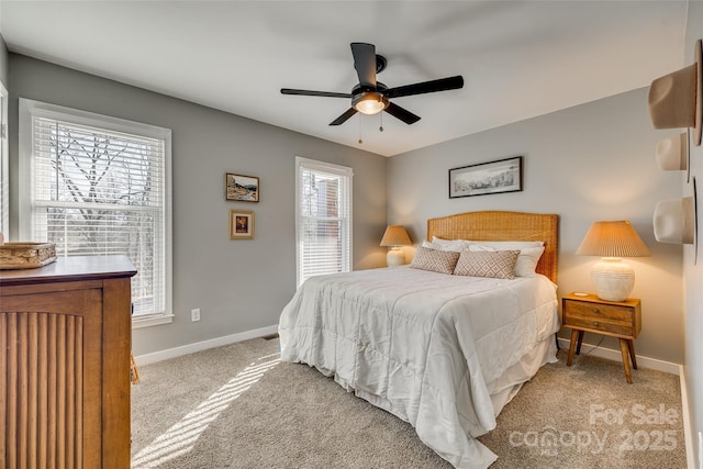 bedroom featuring light carpet, multiple windows, and ceiling fan