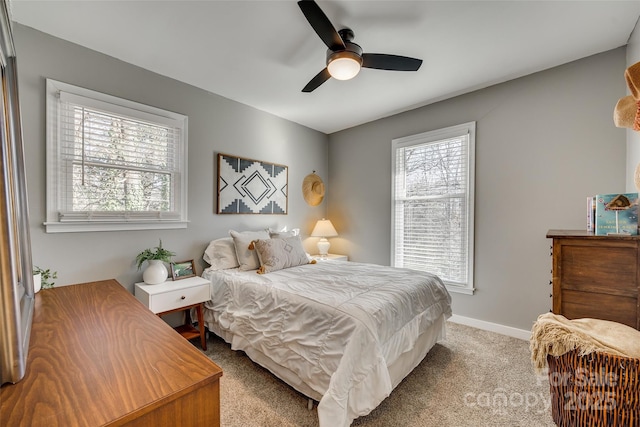 carpeted bedroom with multiple windows and ceiling fan