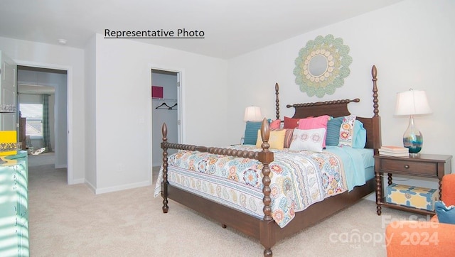 bedroom with light colored carpet and a spacious closet