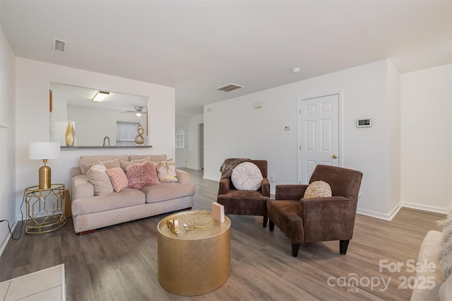 living room featuring wood-type flooring and ceiling fan