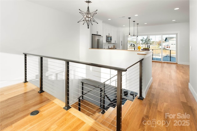 interior space featuring light hardwood / wood-style flooring, an inviting chandelier, and sink