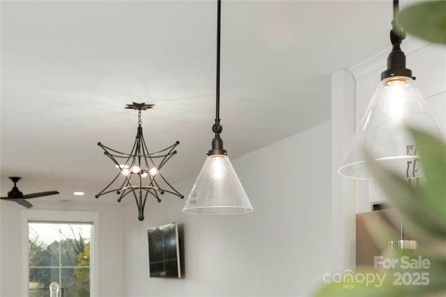 interior details with ceiling fan with notable chandelier