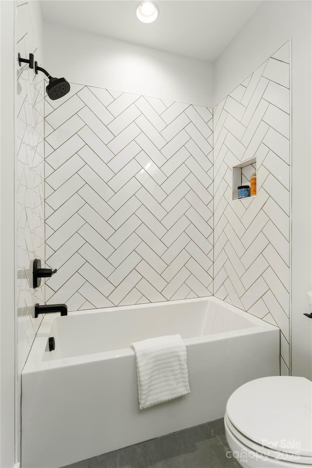 bathroom featuring toilet and tiled shower / bath