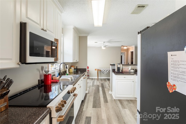 kitchen featuring ceiling fan, sink, high quality range, a textured ceiling, and white cabinets