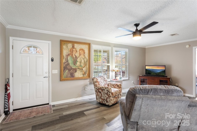 living room with a textured ceiling, hardwood / wood-style flooring, ceiling fan, and crown molding