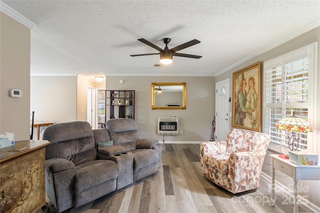 living room featuring ceiling fan, heating unit, crown molding, a textured ceiling, and hardwood / wood-style flooring