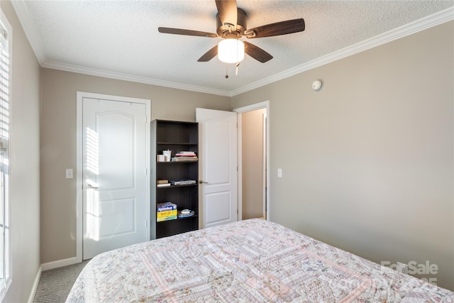 carpeted bedroom featuring a textured ceiling, ceiling fan, and crown molding