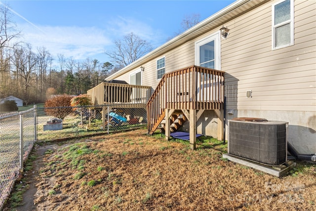 rear view of house featuring cooling unit and a wooden deck