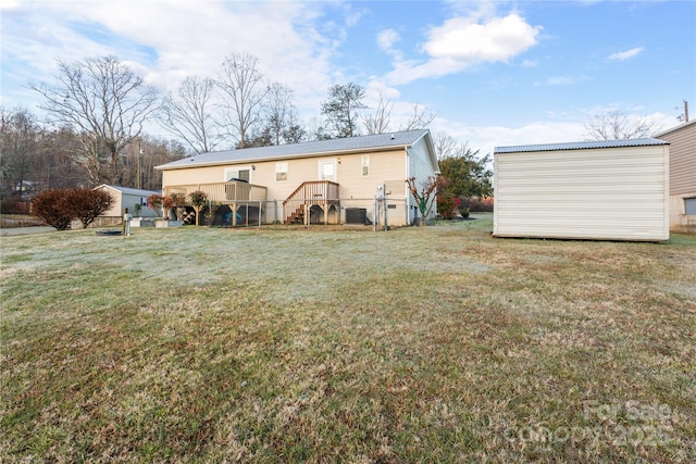 rear view of property with a storage unit, a yard, and a wooden deck