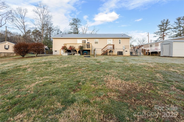 rear view of house with a yard, a storage shed, and a wooden deck