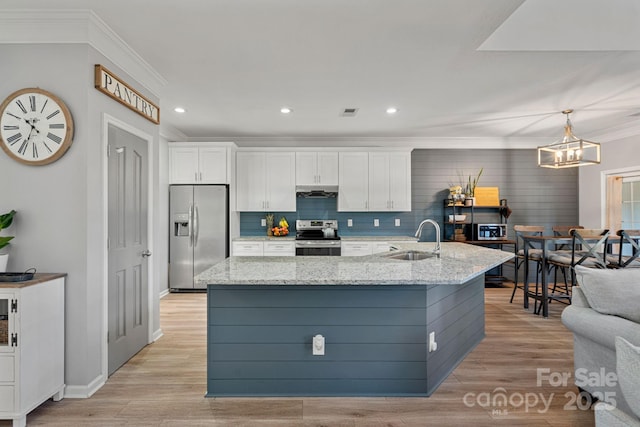 kitchen featuring appliances with stainless steel finishes, white cabinetry, hanging light fixtures, and sink