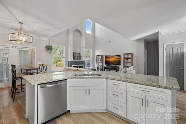 kitchen featuring light stone counters, dishwasher, pendant lighting, white cabinetry, and sink