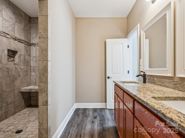 bathroom featuring a tile shower, vanity, and hardwood / wood-style flooring