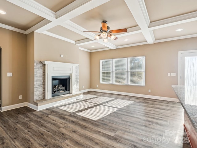 unfurnished living room featuring beam ceiling, dark hardwood / wood-style floors, coffered ceiling, and a healthy amount of sunlight