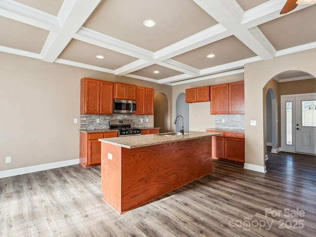 kitchen with tasteful backsplash, sink, an island with sink, and appliances with stainless steel finishes