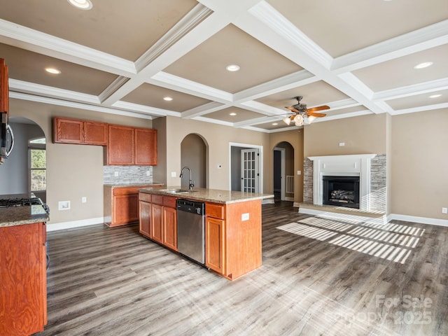 kitchen featuring tasteful backsplash, stainless steel appliances, ceiling fan, sink, and a center island with sink