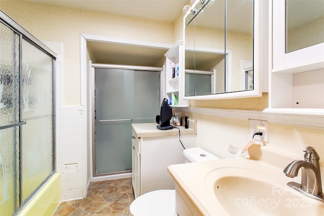 full bathroom with toilet, enclosed tub / shower combo, and vanity