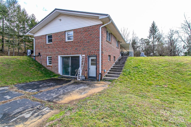 view of side of home featuring a yard and central AC unit