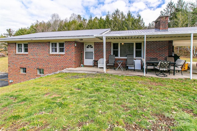 back of house with a yard and a patio