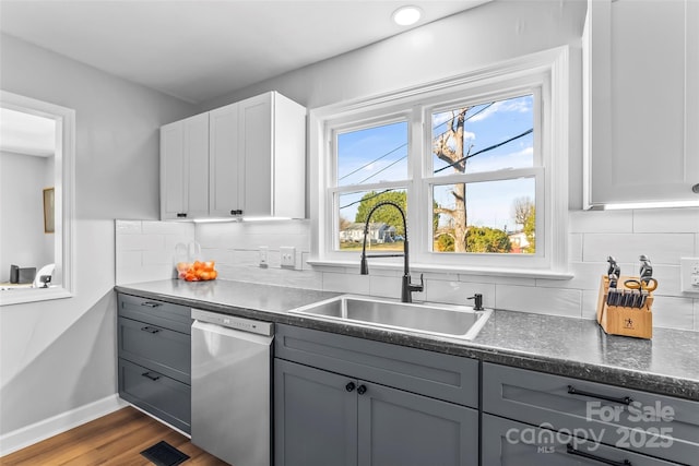 kitchen with dark hardwood / wood-style flooring, white cabinets, gray cabinetry, sink, and dishwasher