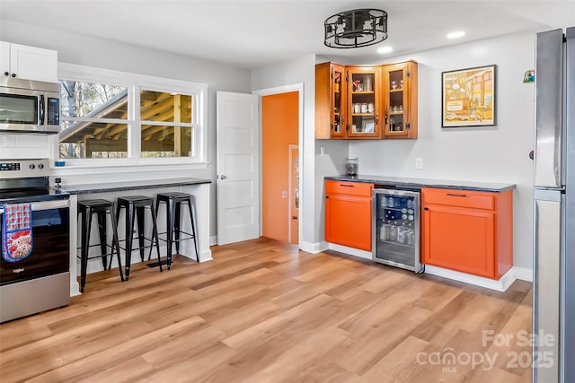 kitchen featuring wine cooler, light wood-type flooring, and appliances with stainless steel finishes