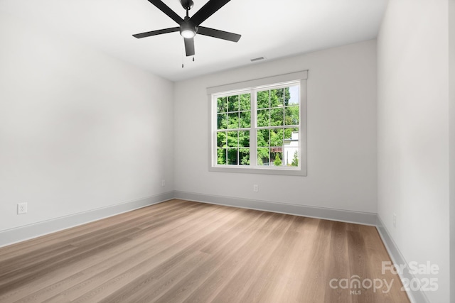 empty room with ceiling fan and light hardwood / wood-style flooring