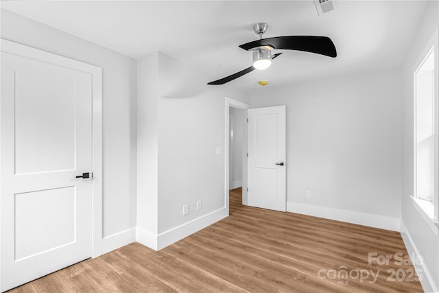 unfurnished bedroom with ceiling fan, a closet, and hardwood / wood-style flooring