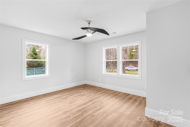 empty room with light hardwood / wood-style flooring, plenty of natural light, and ceiling fan