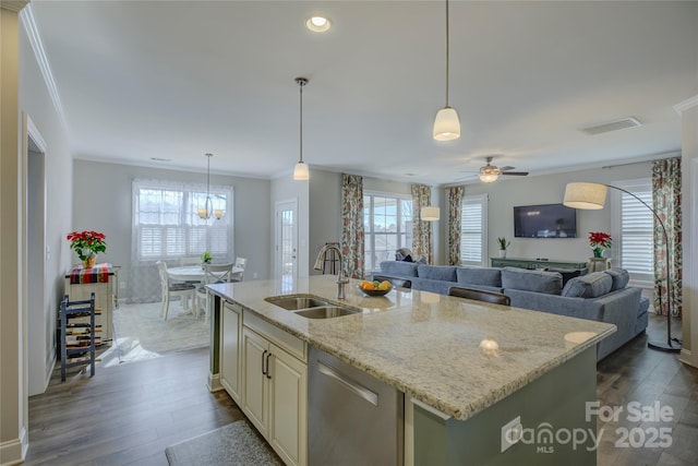 kitchen featuring dishwasher, light stone counters, a kitchen island with sink, and sink