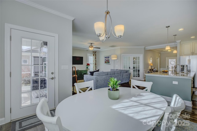 dining space featuring french doors, ceiling fan with notable chandelier, ornamental molding, and hardwood / wood-style floors