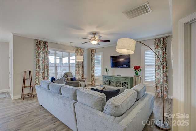 living room with light wood-type flooring, ceiling fan, and crown molding