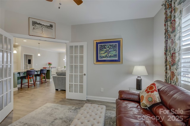 living room featuring ceiling fan, french doors, and light hardwood / wood-style floors