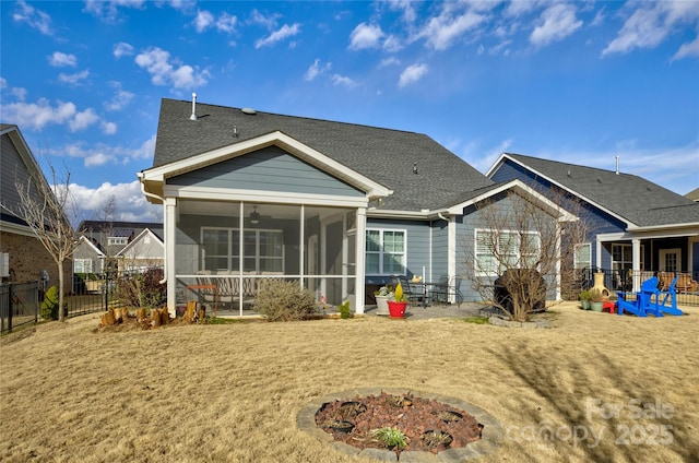 back of house with a sunroom and a fire pit